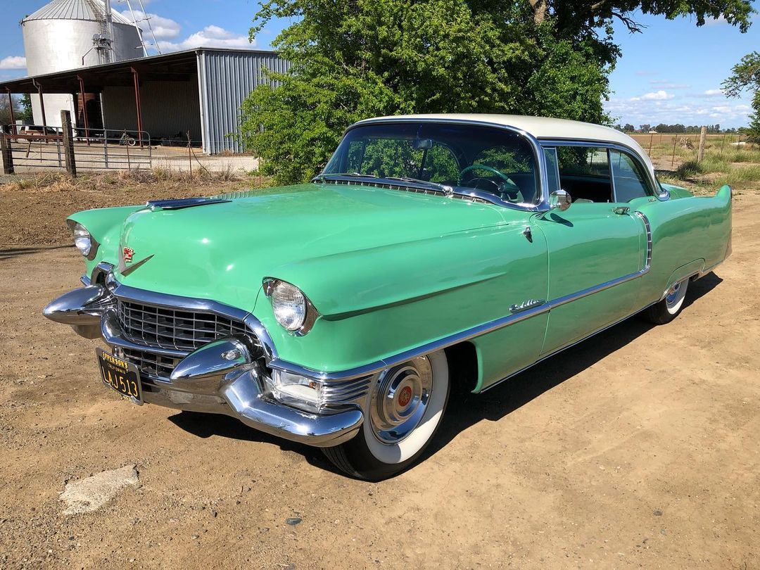 a green Cadillac car parked on the road