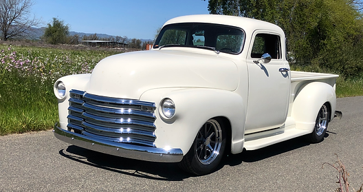 a white classic truck parked on a road